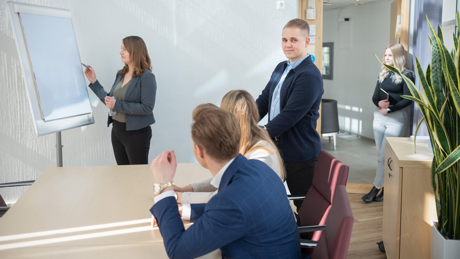 Mavenfirstin asiantuntijat vetämässä yhteen keskustelujen tuloksia markkinoinnin ylimmän johdon kanssa suuressa neuvotteluhuoneessa.